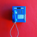 Telephone Bleu sur mur Rouge - Fond iPhone
